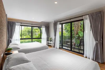 a bedroom with two beds and a large window at Nest by Sangob in Bangkok