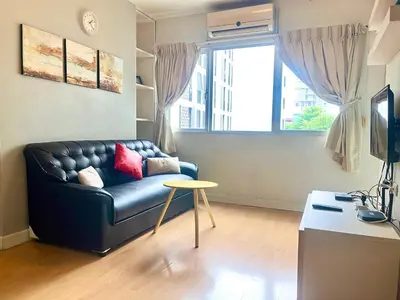 a living room with a black leather couch and a table at 1BR Condo 5 Min to BTS 1000Mbps Fiber Wi-Fi great location in Bangkok