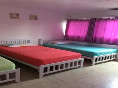 two beds in a room with pink curtains at IMPACT Challenger Muang Thong Thani Service Apartment in Bangkok