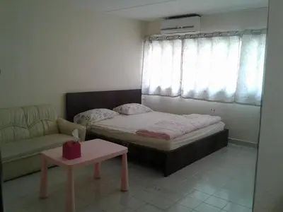a bedroom with a bed and a couch and a table at IMPACT Challenger Muang Thong Thani Service Apartment in Bangkok