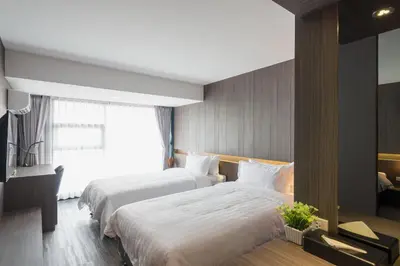 a hotel room with two beds and a window at Fyn Hotel in Bangkok