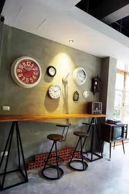 a bunch of clocks on the wall in a room at Hansa Bangkok House in Bangkok