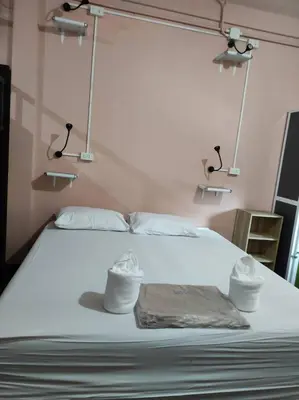 a bedroom with a white bed with two towels on it at Urban Hostel Bangkok in Bangkok