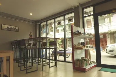 a room with a bar with stools and a window at Urban Hostel Bangkok in Bangkok