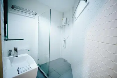 a bathroom with a glass shower and a sink at Urban Hostel Bangkok in Bangkok