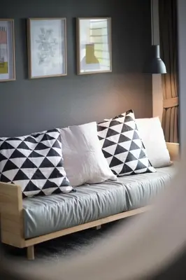 a couch with pillows on it in a living room at The Journey Hotel Laksi in Bangkok