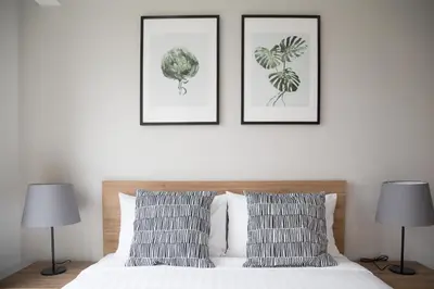 a bedroom with three framed art prints above a bed at The Journey Hotel Laksi in Bangkok