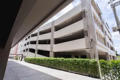 a large white building with a hedge in front of it at The Journey Hotel Laksi in Bangkok