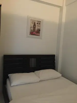 a bed in a bedroom with a picture on the wall at Bann Bunga Inn in Bangkok