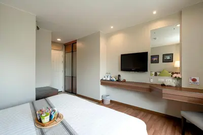 a hotel room with a bed and a flat screen tv at Bangkok Loft Inn in Bangkok