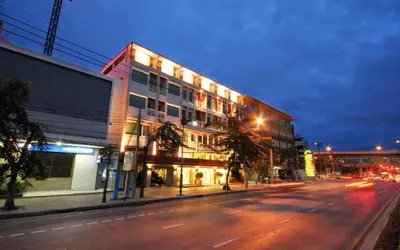 a building on the side of a street at night at Bangkok Loft Inn in Bangkok