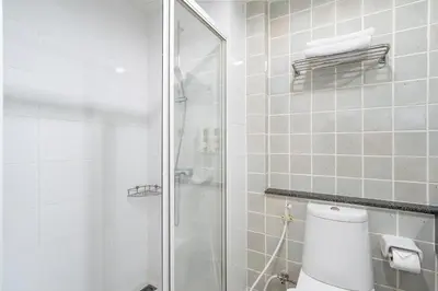 a bathroom with a toilet and a glass shower at Bangkok Loft Inn in Bangkok