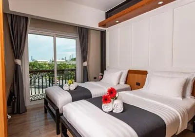 two beds in a hotel room with a balcony at Dang Derm In The Park Khaosan in Bangkok