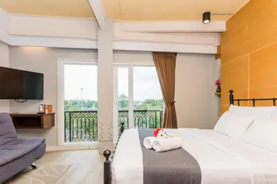 a hotel room with a bed and a balcony at Dang Derm In The Park Khaosan in Bangkok