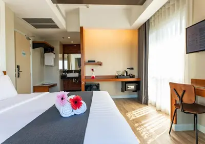 a bedroom with a bed with two flowers on it at Dang Derm In The Park Khaosan in Bangkok