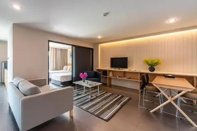 a living room with a couch and a television at Naga Residence in Bangkok