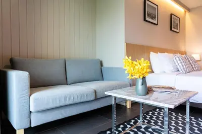 a living room with a couch and a table at Naga Residence in Bangkok