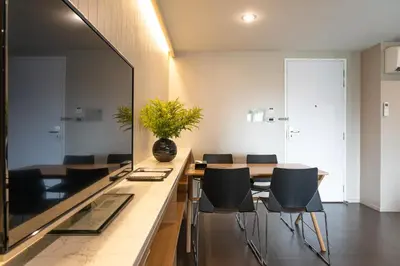 a dining room with a table and chairs and a mirror at Naga Residence in Bangkok