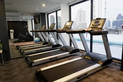 a row of treadmills in a gym with a view at Naga Residence in Bangkok