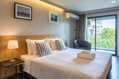 a hotel room with a large bed and a window at Naga Residence in Bangkok