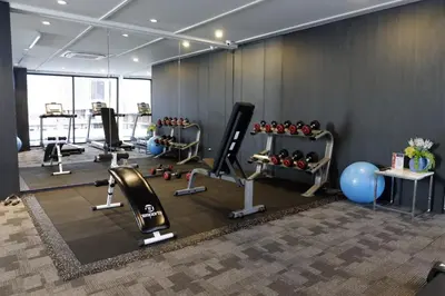 a gym with treadmills and exercise equipment in a room at Naga Residence in Bangkok