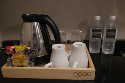 a wooden tray with a coffee maker and bottles of water at Naga Residence in Bangkok