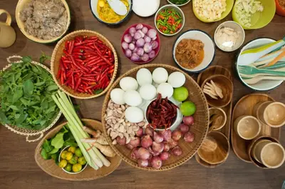 a table topped with baskets of different types of vegetables at Hom Hostel & Cooking Club in Bangkok