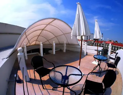 a balcony with chairs and tables and a domineering at Cacha Bed in Bangkok
