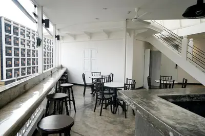 a bar with chairs and tables in a room at Cacha Bed in Bangkok