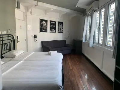 a bedroom with a large bed and a couch at Cacha Bed in Bangkok