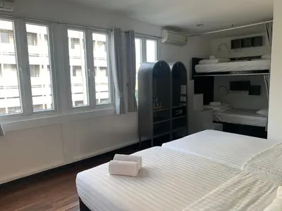 a bedroom with two beds and two windows at Cacha Bed in Bangkok