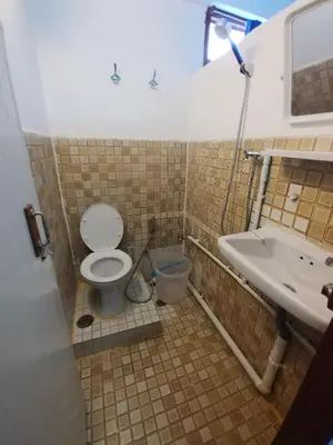 a bathroom with a toilet and a sink at Prasuri Guest House in Bangkok