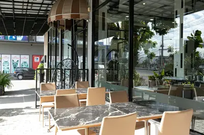 a table and chairs in front of a building at Grand Ratchapruek Hotel in Ban Bang Phlap