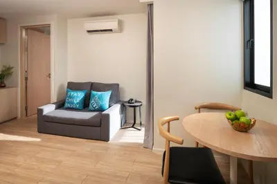 a living room with a chair and a table at Cross Vibe Bangkok Sukhumvit in Bangkok