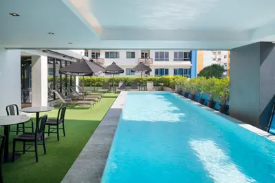 an image of a swimming pool with tables and chairs at Cross Vibe Bangkok Sukhumvit in Bangkok