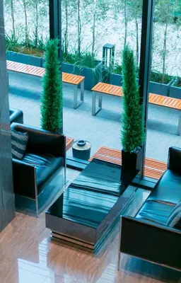 a lobby with two chairs and two potted plants at Spenza Hotel in Bangkok