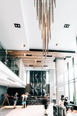a group of people standing in a lobby with a chandelier at Spenza Hotel in Bangkok