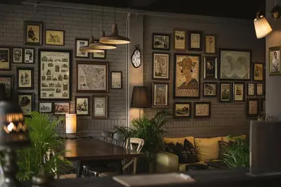 a room with a wall filled with pictures and a couch at Heyyyy Bangkok in Bangkok