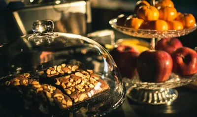 a glass dish filled with nuts and apples on a table at Heyyyy Bangkok in Bangkok
