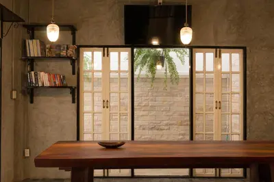 a dining room with a table and a large window at X9Hostel in Bangkok