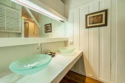 a bathroom with a large blue bowl sink on a counter at Baankachitpan Bangkok Hotel in Bangkok