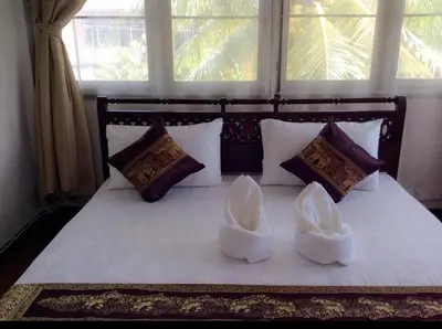 a bed with two white shoes sitting on it at Naturbliss Resort Village in Bangkok