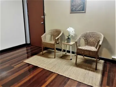 two chairs and a table in a room at Naturbliss Resort Village in Bangkok