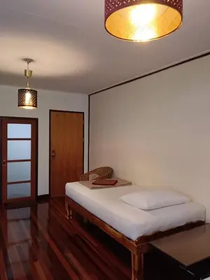 a bedroom with a bed and a light fixture at Naturbliss Resort Village in Bangkok