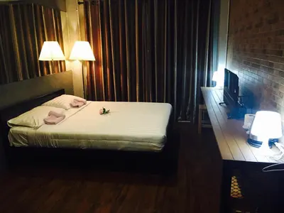 a hotel room with a bed with a flower on it at Popcorn House Ratchada in Bangkok