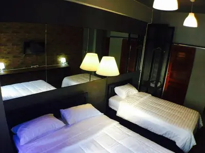 a bedroom with two beds and a mirror at Popcorn House Ratchada in Bangkok