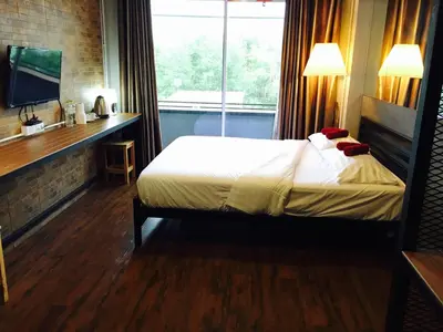 a hotel room with a bed and a window at Popcorn House Ratchada in Bangkok