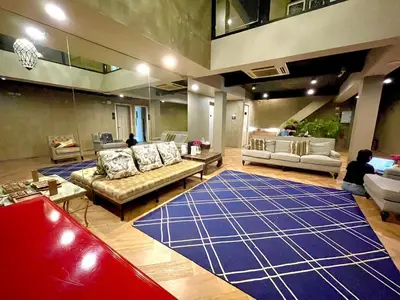 a living room with couches and a large blue rug at Collection O The Spades Hostel in Bangkok