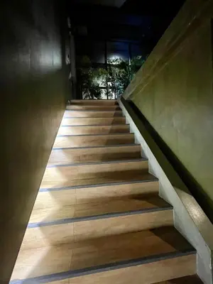 a staircase leading up to a building with wooden floors at Collection O The Spades Hostel in Bangkok