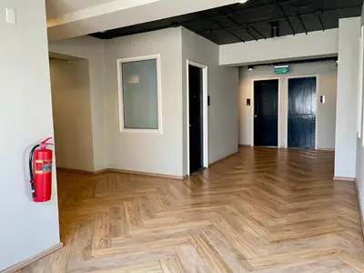 an empty room with a wooden floor and two doors at Collection O The Spades Hostel in Bangkok